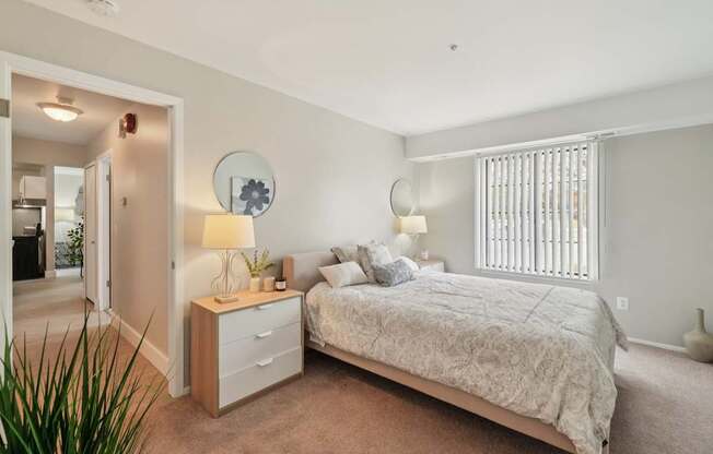 A bedroom with a bed, nightstand, and lamp.