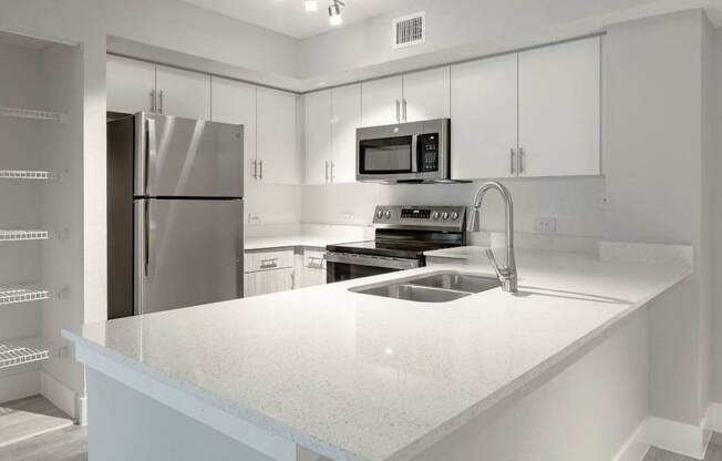 A modern kitchen with a stainless steel refrigerator and a granite countertop.