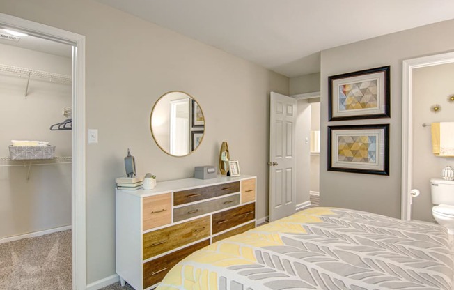 a bedroom with a bed and a dresser with a mirror on top of it at Hunters Chase Apartments, Midlothian