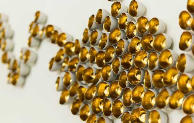 A cluster of gold and white spheres are arranged in a pattern.