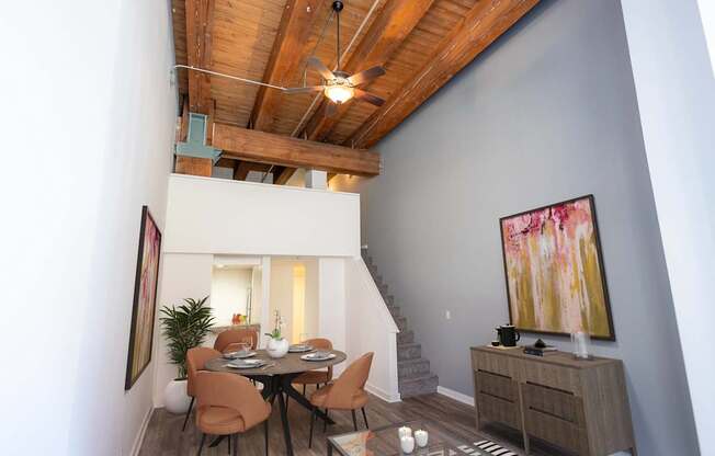 a dining room with a table and chairs and a ceiling with wooden beams at Lowertown Commons Apartments, St. Paul, MN