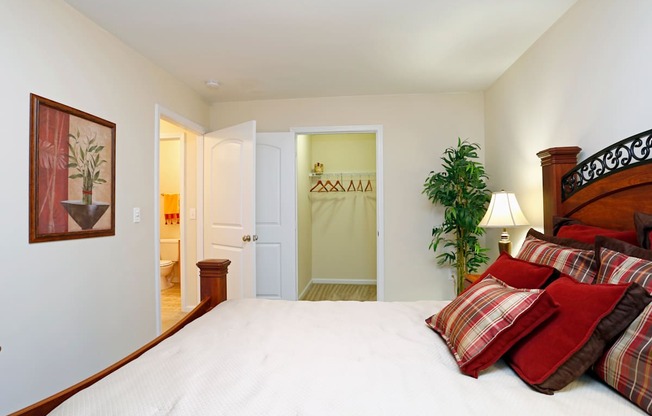 A bedroom with a large bed and a painting on the wall.