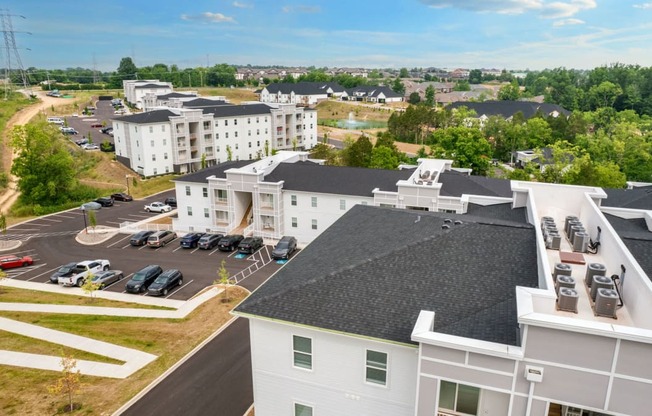 an aerial view of a building with cars parked in a parking lot
