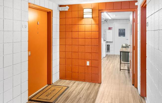 A hallway with orange doors and white walls.