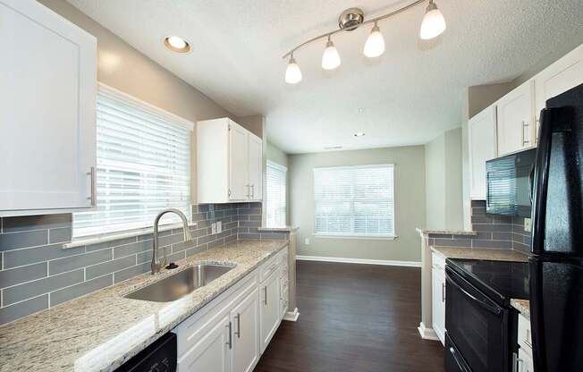 Suites with granite countertops and sleek black appliances (Signature)