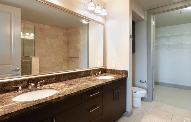 A bathroom with a marble countertop and a white sink.