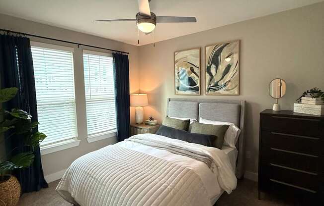 A bedroom with a large bed and a ceiling fan.