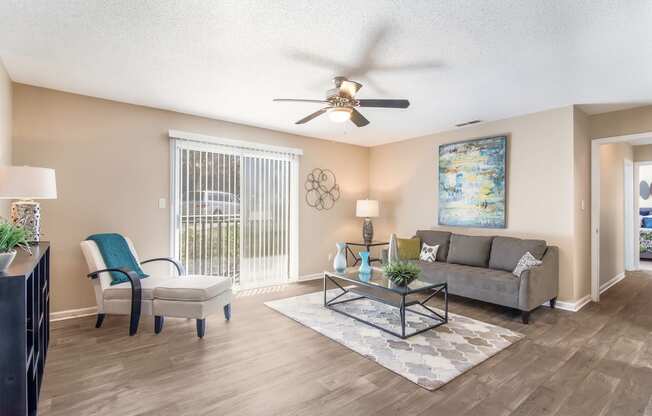 Model living room with a ceiling fan and a couch at Arrowood Crossing Apartments in Charlotte, NC