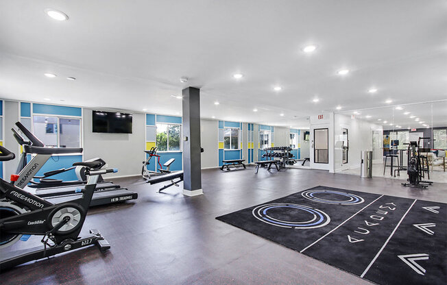 a gym with treadmills and other exercise equipment in a large room