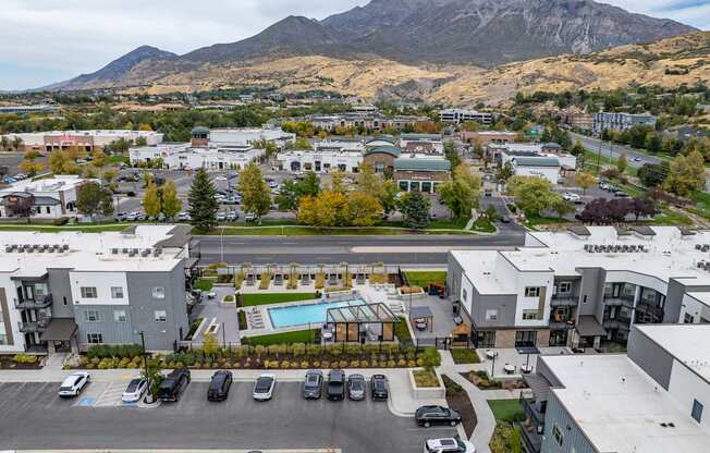 an aerial view of an apartment complex with a pool and parking lot