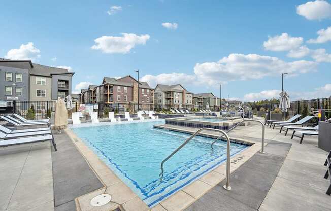 our apartments have a large pool with lounge chairs and umbrellas at The Quarry Luxury Apartment Homes, Fort Collins, CO