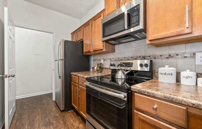 A kitchen with wooden cabinets and black appliances.