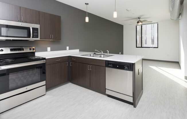 Modern open-concept kitchen and living area with stainless steel appliances.