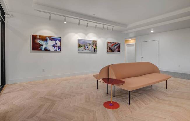 A room with a tan couch and a red table.