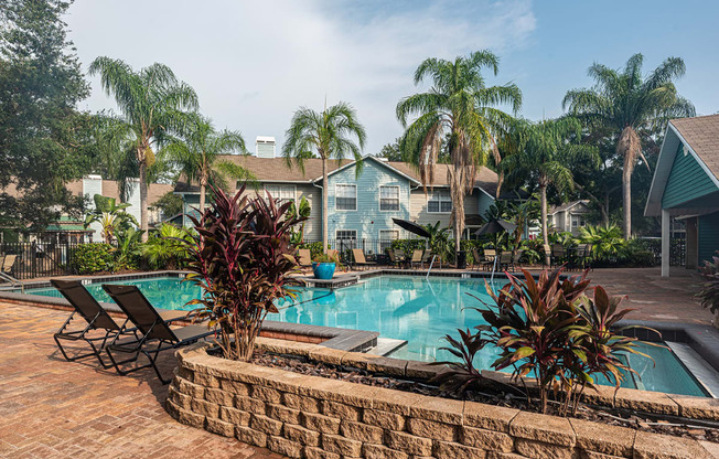 a swimming pool with palm trees in front of a house