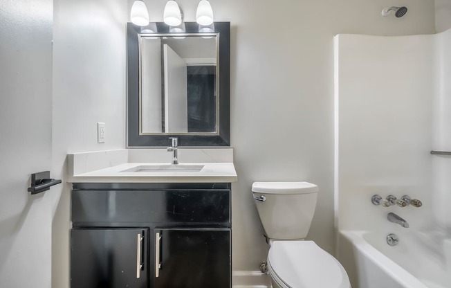 A bathroom with a sink, toilet, and bathtub.at Iris Luxury Apartments, Tennessee