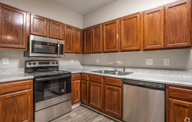 a kitchen with stainless steel appliances and wooden cabinets