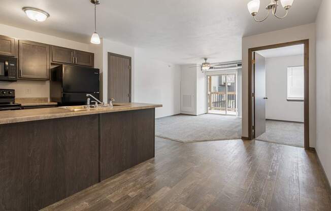 A kitchen with dark wood cabinets and a black stove top oven.