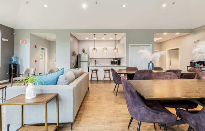 a living and dining room area with a kitchen in the background and a kitchen island in the