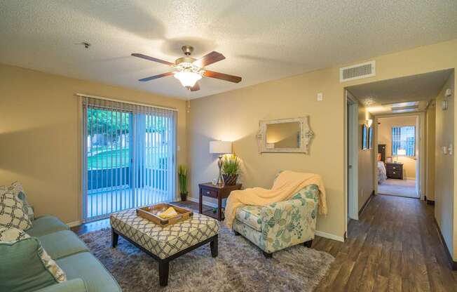 A living room with a couch, chair, and a fan at Sterling Point Apartment Homes, Phoenix