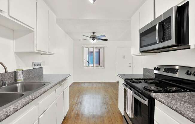 a kitchen with granite counter tops and black appliances at Casa Del Amo Apartments, Torrance, CA 90505