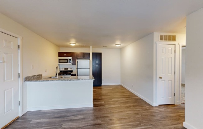 a kitchen and living room with white walls and wood floors at Bennett Ridge Apartments, Oklahoma City, 73132