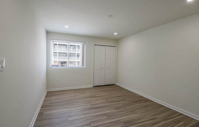 A room with a wooden floor and a window.