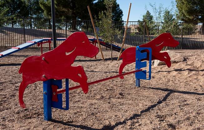 a swing set with two red dogs on it