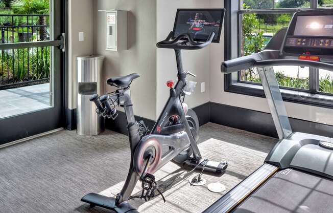 a treadmill and exercise bike in the fitness room