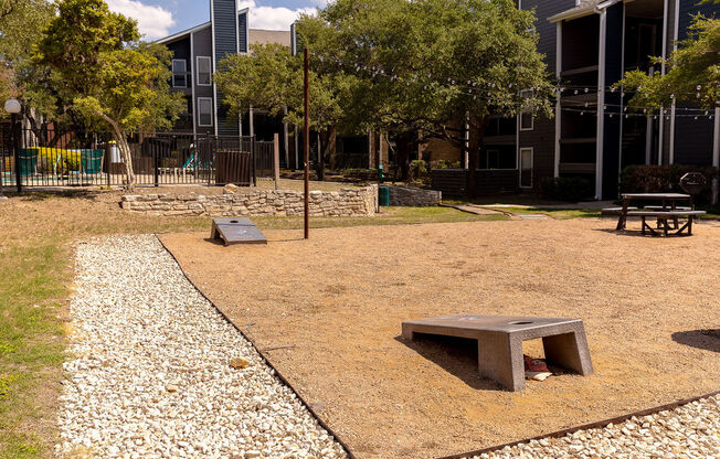 a park with a bench and a table in front of a building at Sunset Canyon, Texas, 78232
