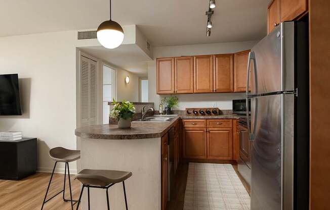 A kitchen with wooden cabinets and a refrigerator.