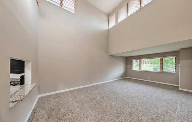 A spacious room with a large window and high ceilings