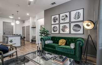 a living room with a green couch and a glass table