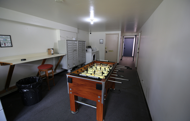 Chic recreational area with a foosball table, modern mailboxes, and laundry facilities, perfect for relaxation and convenience.