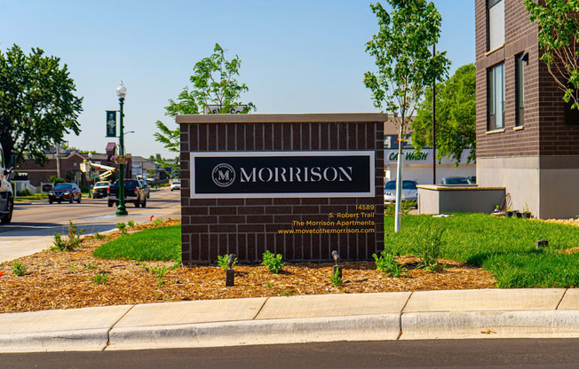 a sign on the side of a road with a building in the background