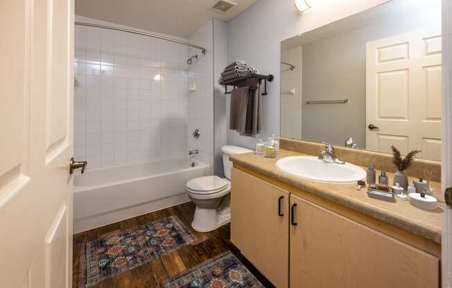 a bathroom with a toilet sink and tub and a mirror