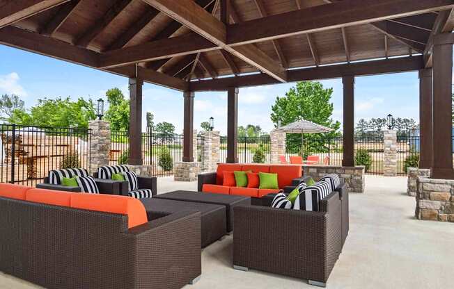 A patio with a brown roof and furniture.