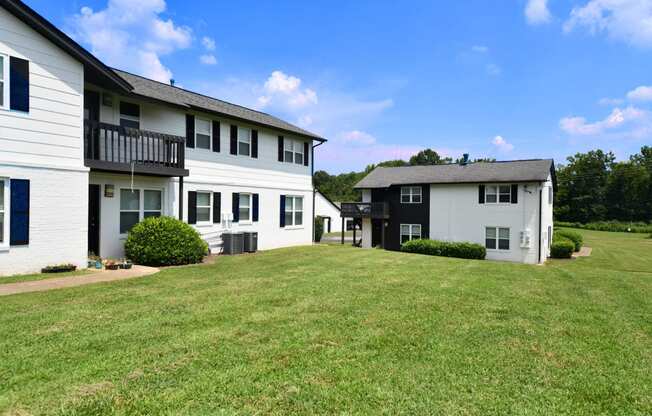 a view of two houses on a grassy area