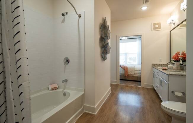 a bathroom with a tub and a sink and a toilet at The Quincy Apartments, Acworth, GA
