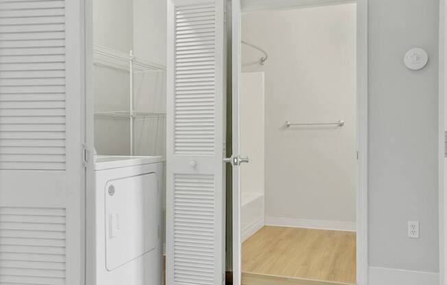 A white refrigerator is in a kitchen with a white door.