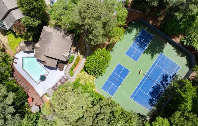 arial view of a house with a tennis court and a pool