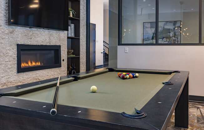 a pool table in the clubroom with a firepit