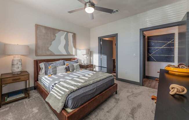 A bedroom with a large bed and a ceiling fan.