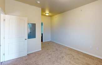 a bedroom with a white door and a carpeted floor