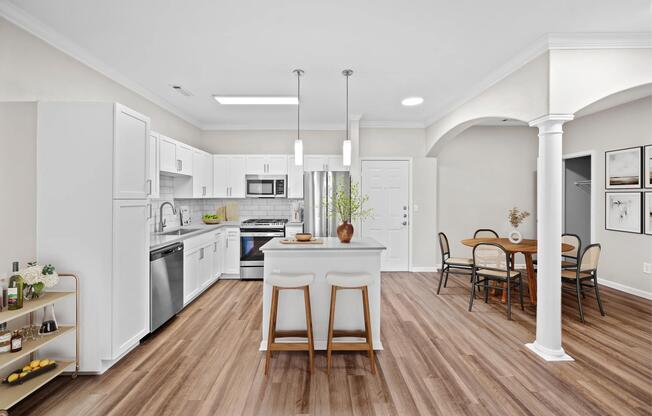Kitchen and dining area with architectural columns, a spacious island, and an open layout that brings everyday meals and gatherings together.