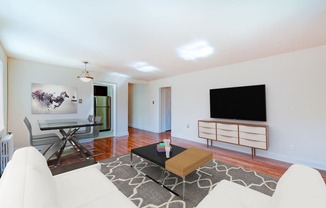 living area with credenza, tv, sofa, coffee table, hardwood floors and view of dining area at hillside terrace apartments in washington dc