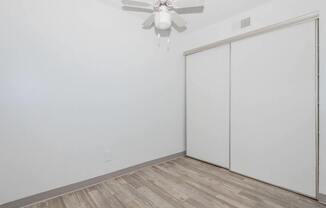A room with a ceiling fan and a sliding door.