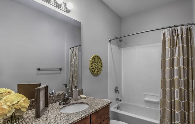 a bathroom with a shower and a sink and a mirror