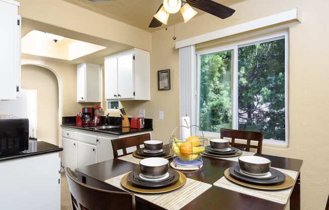 a kitchen and dining room with a table and chairs and a large window