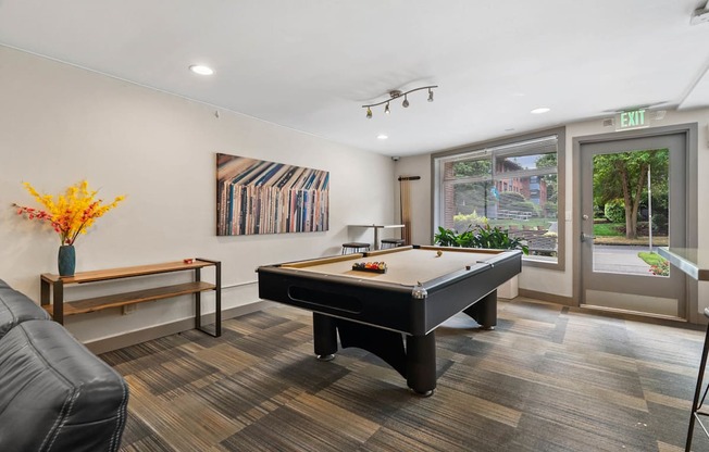 A room with a pool table and a bench.